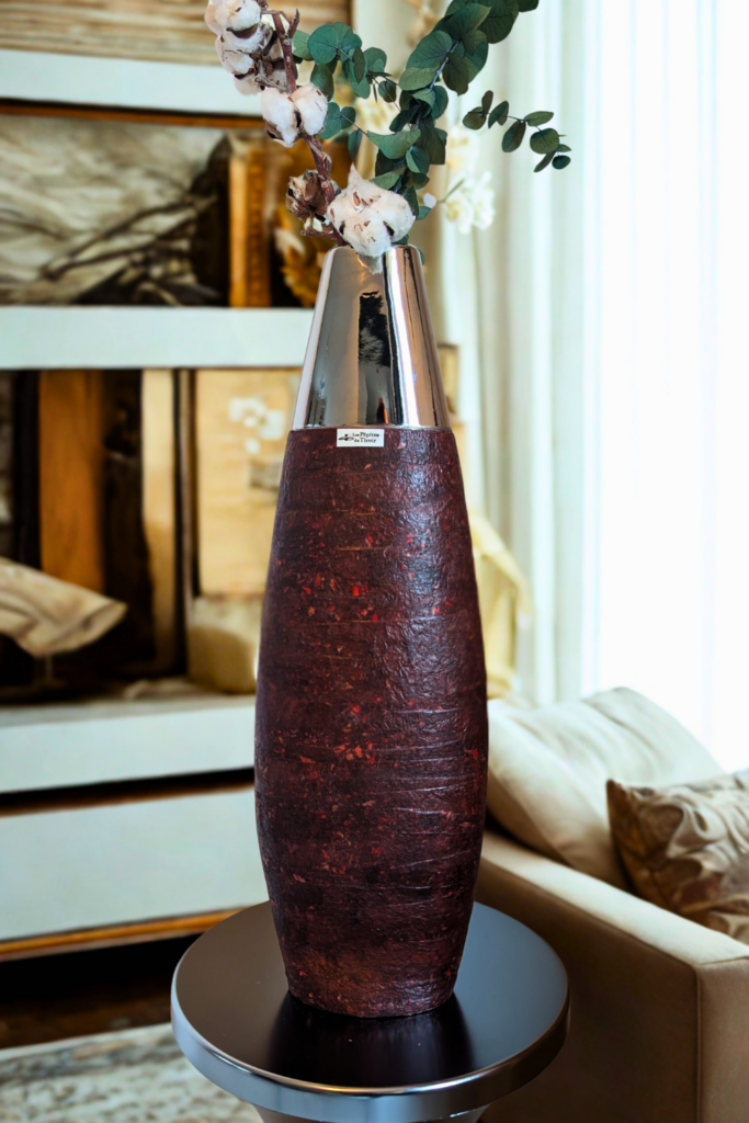 Mise en scène d'une décoration intérieure avec le vase bordeaux et chromé Les Pépites du Tiroir posé sur un tabouret Tam Tam Chromé.