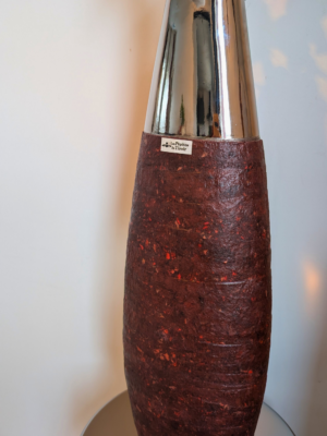 Détail du contraste entre la texture mate bordeaux/ lie de vin et la base en métal chromé miroir, vase design issu de l'écodesign et du recyclage.
